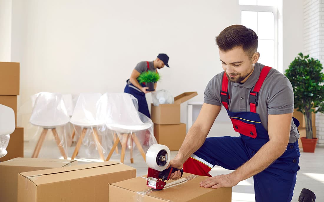 Verpacken von Umzugkartons durch Schenck und Hansen Mitarbeiter - Querformat